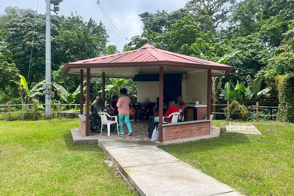Jardín o zona exterior de Sociedad San Vicente de Paúl Manizales - Hogar El Paraíso. Los rostros aparecen difuminados.