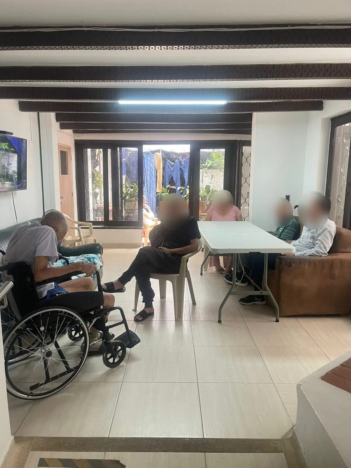 Zona común de Hogar Geriátrico Sonríe a la Vida. Los rostros aparecen difuminados.