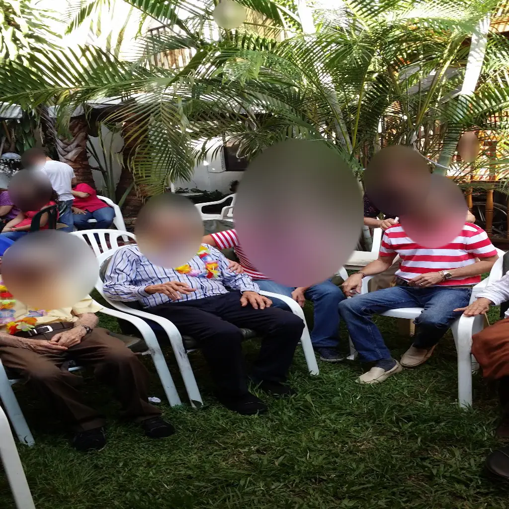 Jardín o zona exterior de Manantiales Hogar del Adulto Mayor. Los rostros aparecen difuminados.